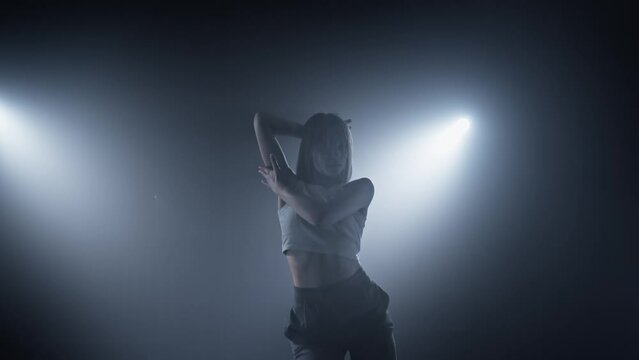 Sensual woman enjoying dance in smoky studio with beautiful light. Performance. Graceful female dancing in dark room with spotlights. Nightlife. Talented woman dancing. 4K, UHD