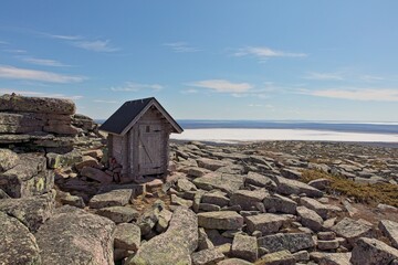 Toilet with a view on top of Pyhä-Nattanen fell in spring with clouds in the sky, Sompio Strict...