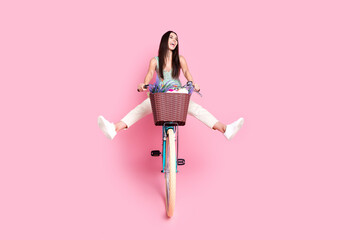 Photo of cool cheerful nice cute woman wear trendy clothes ride bicycle isolated on pink color...