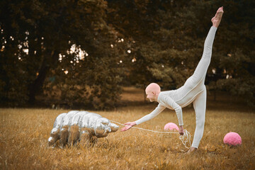 Portrait of young hairless girl ballerina with alopecia in white cloth playing with tardigrade toy...