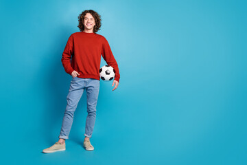 Full length photo of handsome good mood guy wear red sweater holding football ball emtpy space...