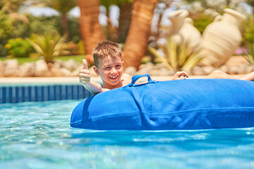 Picture of a small boy having fun in aquapark outdoor on tube