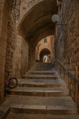 Winding stone footpath leading to a set of steps, surrounded by lush green foliage: Jerusalem