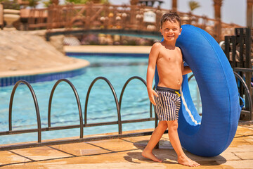 Picture of a small boy having fun in aquapark outdoor on tube