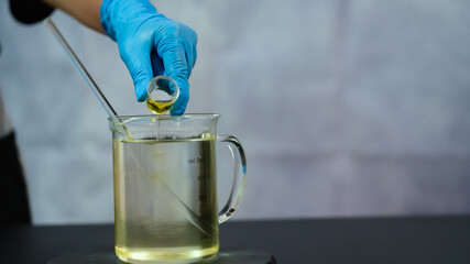 Lab Technician Adding Chemical to Solution in Beaker.