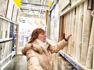 Middle-Aged Woman Shopping at a Warehouse Store. Woman browsing in a large retail store aisle