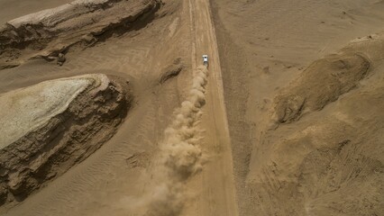 Aerial view of a car riding through the desert