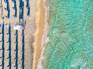 Salento: spiaggia con gli ombrelloni e il mare  turchese cristallino - Puglia, Taranto, Italia