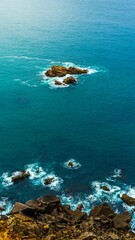 Vertical shot of a rocky cliff edge with a magnificent view of the ocean