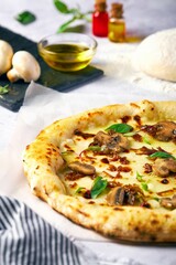 a pizza with meat and mushroom is displayed on a table