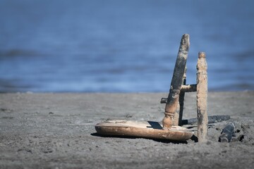 Fototapeta premium two sticks sticking out of the sand near water and rocks
