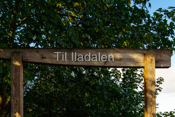 Wood sign maked Til Iladalen on it - Hike to see waterfall on the Ilabekken river by the city of Trondheim, Norway