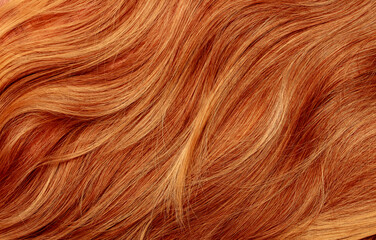 Red hair close-up as a background. Women's long orange hair. Beautifully styled wavy shiny curls....