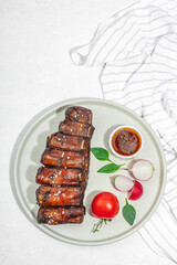 Baked pork ribs with spices, vegetables and sauce. Traditional ingredient for BBQ, picnic concept