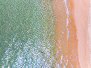 Aerial view of sea crashing waves White foaming waves on beach sand,Top view beach sea surface, Nature sea beach sand background