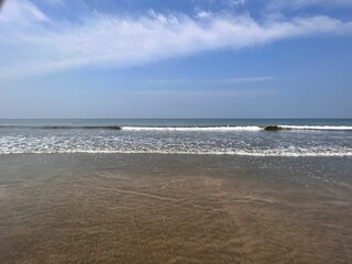 Tranquil ocean with white-crested waves lapping against the shoreline