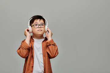 Charming boy with Down syndrome blissfully listens to music on headphones.