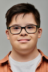 Fototapeta premium Charming little boy with Down syndrome smiling warmly at the camera