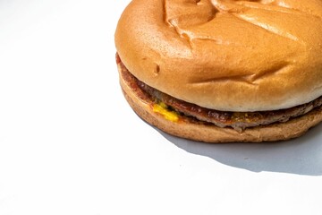 Delicious hamburger with a fresh, juicy patty and crisp toppings placed on a white surface
