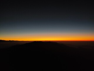 the sunrise seen from the top of a mountain at night
