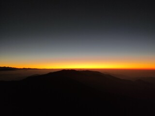 Breathtaking image of a majestic mountain silhouetted against a vibrant sunset sky