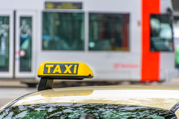 Taxi sign on roof of Taxi in Düsseldorf, Germany. Select focus, blurred background	