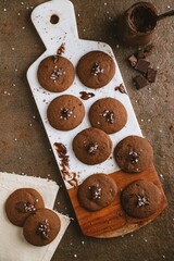 Delicious assortment of chocolate cookies on a wooden cutting board.
