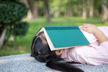 Girl sleeping with a book in the garden
