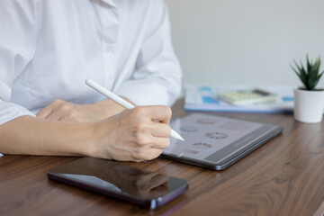 Business woman working at her office desk with documents and tablet