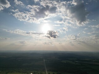 Aerial view of a green landscape under a cloudy sky on a sunny day