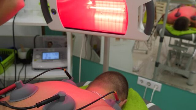 A patient undergoing an electrotherapy with the infrared therapy at the physiotherapist