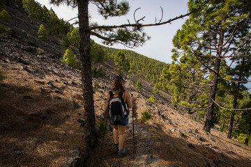 Naklejka premium A young woman walking towards Birigoyo peak, La Palma Island, Canary Islands.