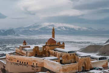 Naklejka premium Aerial view of Ishak Pasha Palace with snow-capped mountains in the background. Turkey.