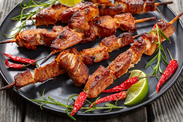 roasted juicy pork kebabs on plate, top view
