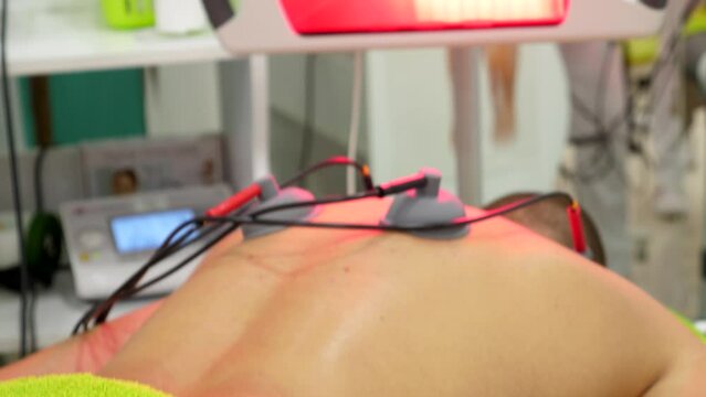 Footage of a back pain infrared and electrotherapy treatment at the physiotherapist