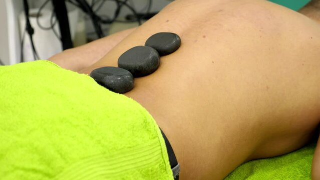 Footage of a hot stone treatment at the physiotherapist