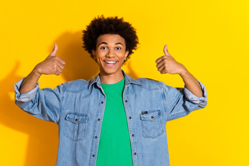 Photo of nice young man show thumb up wear denim shirt isolated on yellow color background