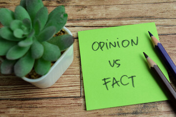 Concept of Opinion vs Fact write on sticky notes isolated on Wooden Table.