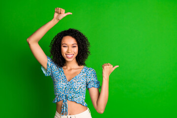 Photo of nice young woman indicate fingers empty space wear top isolated on green color background