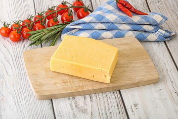 Piece of natural organic cheese over board