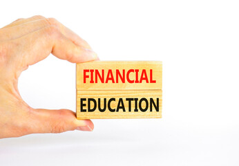Financial education symbol. Concept words Financial education on beautiful wooden block. Beautiful white paper background. Businessman hand. Business Financial education concept. Copy space.
