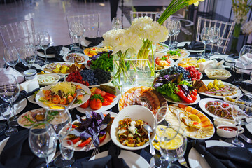 Beautifully set banquet table with black tablecloth. S