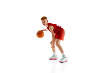 Concentrated and motivated athlete, boy in red uniform practicing basketball, playing with ball...