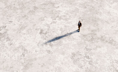 Fototapeta premium Man casting long shadow on empty ground
