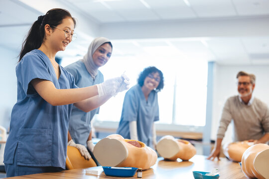 Asian medical student demonstrating how to give an injection in front of her class