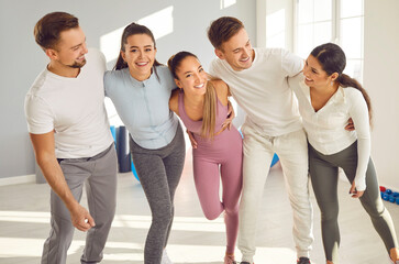 Group of athletes hugging looking into camera smiling and posing. Athletes embody spirit of teamwork and support bond shared among athletes Friendship teamwork mutual encouragement in sports