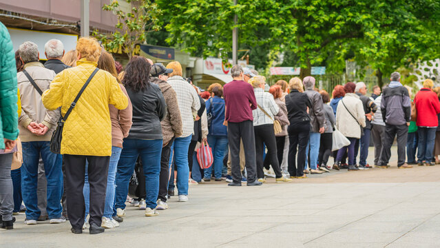 Group of people standing in line outdoors, municipal or other public event