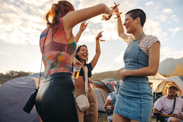 Group of female friends enjoy themselves with dance and celebration at a music festival