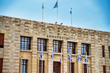 Town hall in the center of Rhodes city with Greek flags.
