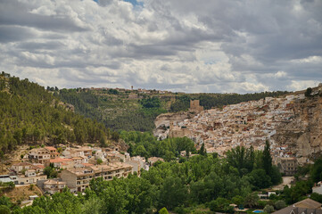 Naklejka premium The white houses anchored to the canyon of the Júcar river in the town of Alcalá del Júcar in Albacete. Castilla la Mancha. Spain
